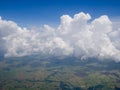 Clouds from airplane window with blue sky and high angle ground