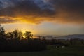 Clouds are beautifully lit by the setting sun that slowly disappears behind the shrubbery in Geer Polder near Zoetermeer, Netherla Royalty Free Stock Photo