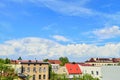 Clouds in the blue sky above the roofs of multi-family houses. Summer. Day Royalty Free Stock Photo