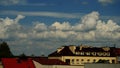 Clouds in the blue sky above the roofs of multi-family houses. Summer. Day Royalty Free Stock Photo