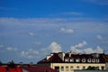 Clouds in the blue sky above the roofs of multi-family houses. Summer. Day Royalty Free Stock Photo