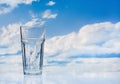 Clouds, blue sky, glass with fresh water. Royalty Free Stock Photo