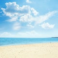 Low clouds in blue sky over sea and sand Royalty Free Stock Photo