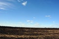 Clouds on a blue spring sky over a plowed field humus Royalty Free Stock Photo