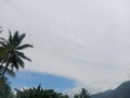 clouds, coconut trees, and mountains Royalty Free Stock Photo