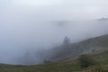 Clouds covering a hillside. With figures emerging ftom the fog on a winters day. Malvern Hills, UK