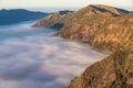 Clouds covering valley at Mt Bromo, Indonesia. Pushing against steep hills . Royalty Free Stock Photo