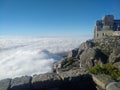 Clouds creeping up the Mountainside to engulf the Cableway buildings that are on the edge of table mountain Royalty Free Stock Photo