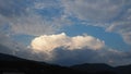 Clouds in the evening sky. The sun's rays pierce the clouds. Blue, yellow and gray colors of the sky and clouds Royalty Free Stock Photo