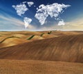 Clouds in the form of a map of the world over the field. Travel and landscape concept Royalty Free Stock Photo