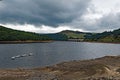 Clouds gather over the dry slopes and banks of Lady Bower reservoir in late summer. Royalty Free Stock Photo