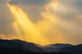 Clouds and golden sunbeam over mountain