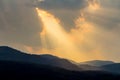 Clouds and golden sunbeam over mountain