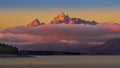 Clouds hanging over Jackson Lake as the sun rises and lights up the tallest peaks of Grand Teton National Park Royalty Free Stock Photo