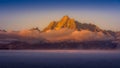Clouds hanging over Jackson Lake as the sun rises and lights up the tallest peaks of Grand Teton National Park Royalty Free Stock Photo