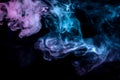 Clouds of colored smoke: blue, red, green, pink; scrolling on a black background in the close up Royalty Free Stock Photo