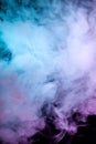 Clouds of isolated colored smoke: blue, red, green, pink; scrolling on a black background in the dark close up Royalty Free Stock Photo