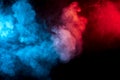 Clouds of isolated colored smoke: blue, red, orange, pink; scrolling on a black background in the dark Royalty Free Stock Photo