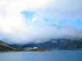 Dammed mountain lake high alpine landscape in clouds