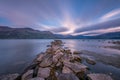 Clouds movements over a stones jetty at dawn at Lake Wanaka in New Zealand Royalty Free Stock Photo