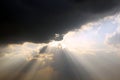 The clouds are multicolored, thunderous bizarre shapes against the blue sky and the sun above the ocean surface.