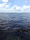 Clouds over calm deep blue water