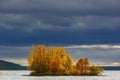 Clouds over an island in a lake in the mountainous part of the tundra in autumn