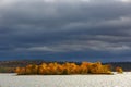 Clouds over an island in a lake in the mountainous part of the tundra in autumn