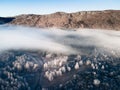 Clouds over the mountains and forest at foggy sunrise. Aerial view Royalty Free Stock Photo