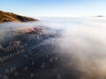 Clouds over the mountains and forest at foggy sunrise. Winter landscape Royalty Free Stock Photo