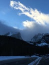 Clouds over snow capped mountain peaks and parking lot. Royalty Free Stock Photo