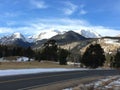 Clouds over snow capped mountain peaks and road. Royalty Free Stock Photo