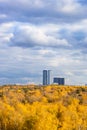 Clouds over yellow forest and high-rise buildings Royalty Free Stock Photo