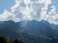 Through the clouds, the rays of the sun break through the mountains. Rosa Khutor Royalty Free Stock Photo