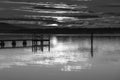 Clouds, reflections and sunrise over the bay in black and white Royalty Free Stock Photo