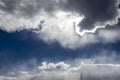 Clouds with silver lining - dark cloud lined with white in dark blue sky with tumultous clouds surrounding Royalty Free Stock Photo