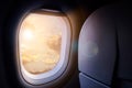 Clouds and sky with golden sunlight and lens flare as seen through window of an aircraft Royalty Free Stock Photo