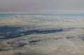 Clouds sky as seen through window of an aircraft under high clouds located