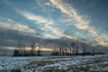 Clouds in the sky during sunset over a meadow with trees, winter December Royalty Free Stock Photo