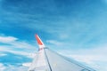 Clouds, sky and wing aeroplane as seen through window of an aircraft