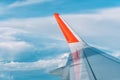 Clouds, sky and wing aeroplane as seen through window of an aircraft