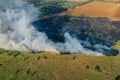 Clouds of smoke above dry burning field, natural disaster wildfire. Burning nature with fire, aerial view