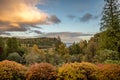 Clouds start to turn orange at sunset looking out over the calm water and bright fall colors near Stonefield Castle in Argyll