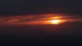 The clouds at sunset hide the sun. Smoke from the chimney of an industrial plant is visible at the bottom of the frame