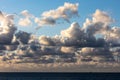 Cloudscape over the sea with dark clouds from below and white clouds from above Royalty Free Stock Photo