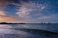 Tranquil pink sunrise seascape with cumulus clouds over the jetty and ruined piers