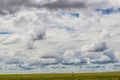 Cloudscape on the plains with windmill in the distance - Big sky country Royalty Free Stock Photo