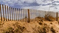 Cloudscape Through the Wind Fence on the Dunes Royalty Free Stock Photo