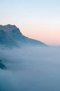 Cloudy alpine landscape with mountain range silhouette during sunset