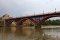 Cloudy autumn day in Maribor. Old Bridge over Drava River reflected in water. Group of white swans swimming near the river bank. Royalty Free Stock Photo